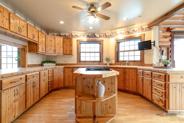 kitchen with tile counters, a wealth of natural light, and light wood-style floors