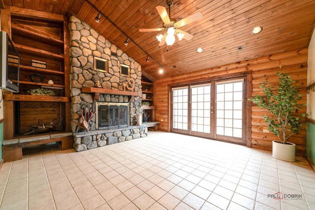 unfurnished living room with a stone fireplace, wooden walls, visible vents, wood ceiling, and tile patterned floors