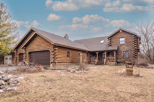 cabin featuring an attached garage, a chimney, log siding, and a porch