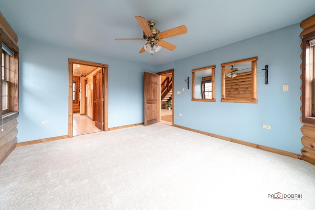 empty room featuring carpet flooring, a ceiling fan, and baseboards