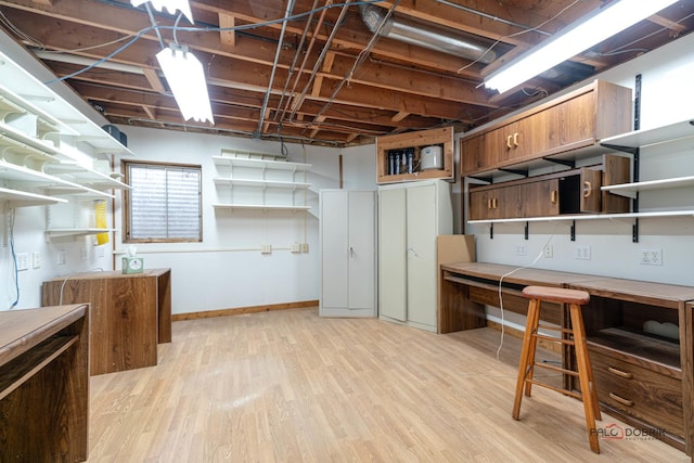 unfinished below grade area featuring light wood-style floors and baseboards