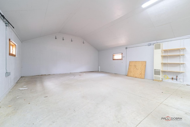 additional living space featuring lofted ceiling and concrete floors