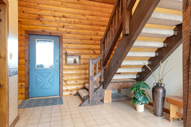 tiled foyer entrance with log walls and stairway