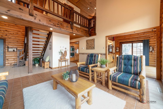 tiled living area with a high ceiling, stairway, log walls, and recessed lighting