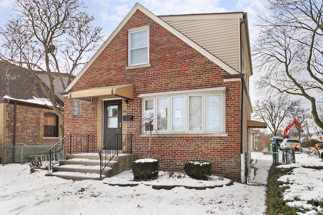 view of front of home featuring fence and brick siding