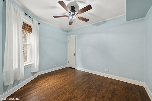 unfurnished room featuring dark wood-style floors, crown molding, a ceiling fan, and baseboards