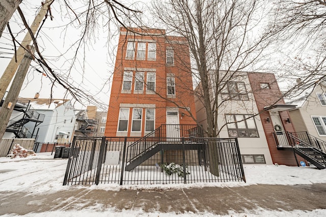 multi unit property featuring a fenced front yard and brick siding