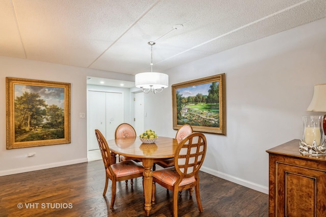 dining room featuring a notable chandelier, dark wood-type flooring, and a textured ceiling