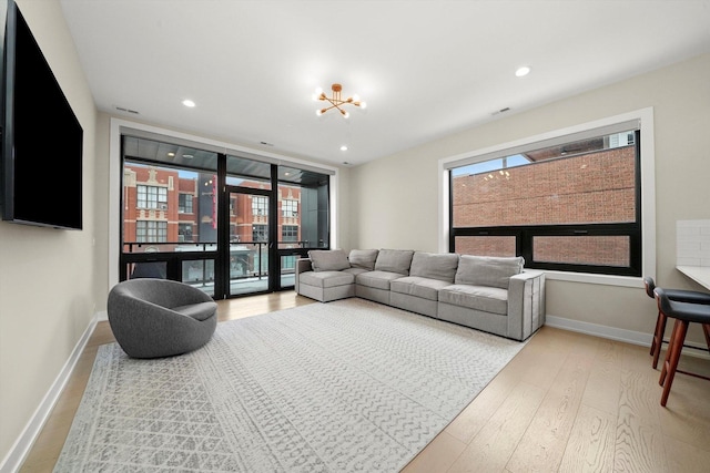 living room featuring recessed lighting, wood finished floors, a wealth of natural light, and baseboards