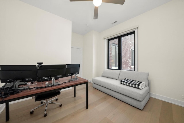 home office with a ceiling fan, wood finished floors, visible vents, and baseboards