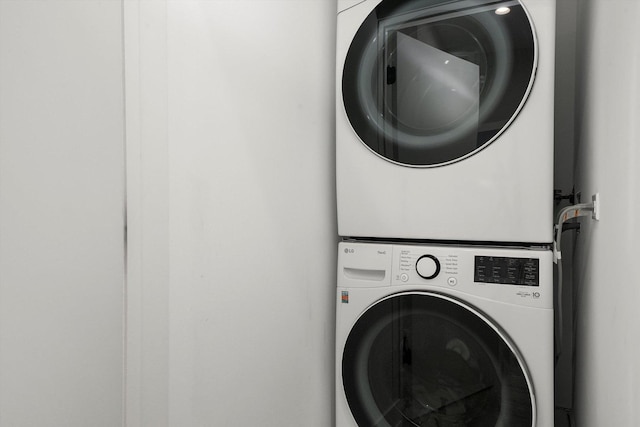 washroom with stacked washer and dryer and laundry area