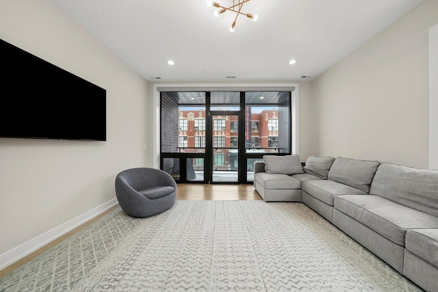 living area featuring recessed lighting, floor to ceiling windows, baseboards, and wood finished floors