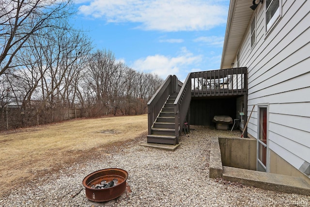 view of yard with a wooden deck and a fire pit