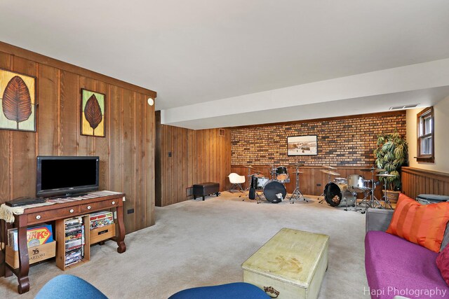 living room with brick wall, wood walls, and light colored carpet