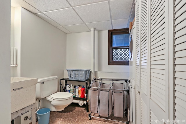 bathroom with a drop ceiling, sink, and toilet