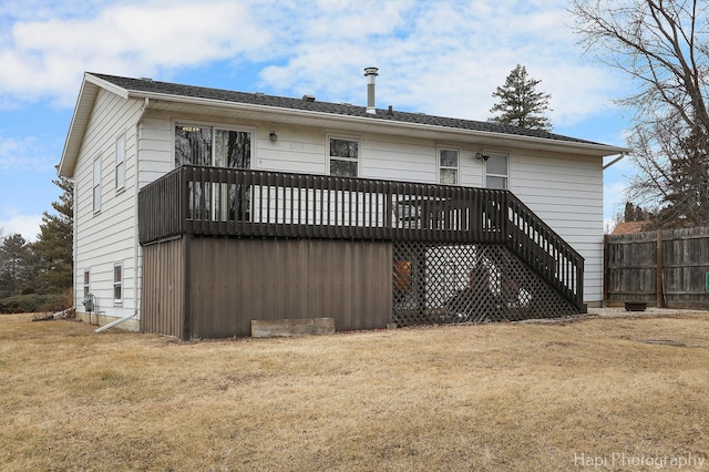 back of property with a yard and a wooden deck