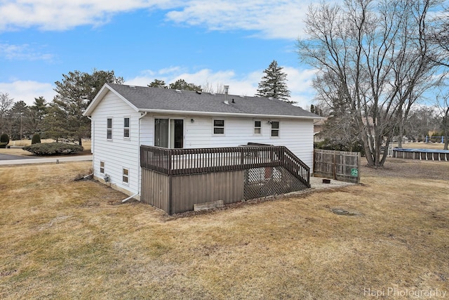 back of house with a deck and a lawn