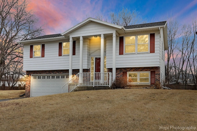 bi-level home with a yard and a garage