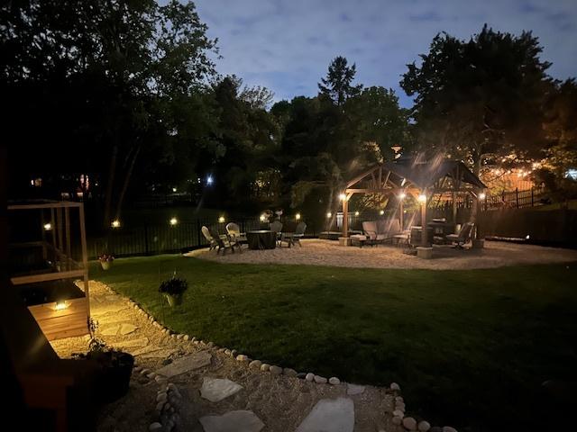 yard at dusk featuring a patio area, fence, and a gazebo