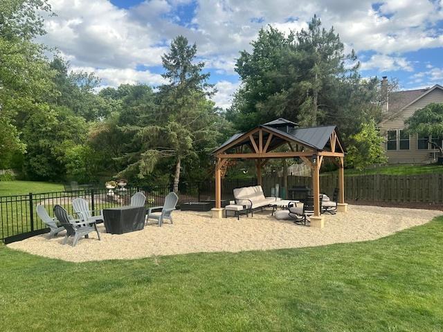 view of playground featuring fence, a gazebo, and a lawn