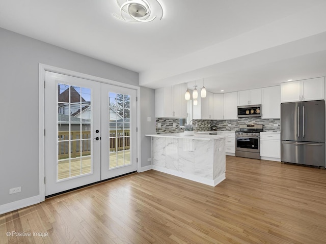 kitchen featuring white cabinetry, kitchen peninsula, appliances with stainless steel finishes, and french doors