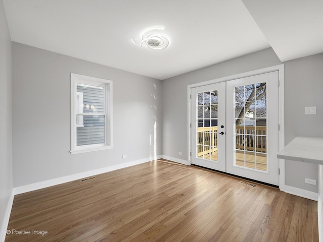 empty room with french doors and hardwood / wood-style floors