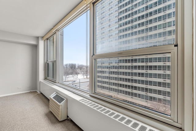 empty room with carpet floors, an AC wall unit, and baseboards