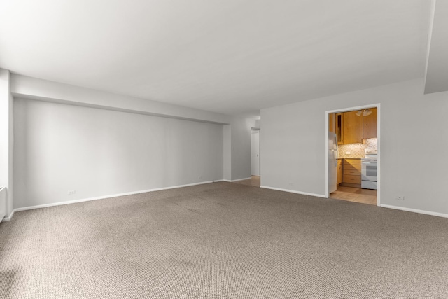 unfurnished room with light colored carpet and baseboards