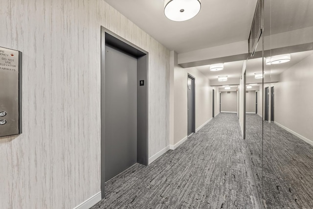 hall with baseboards and elevator