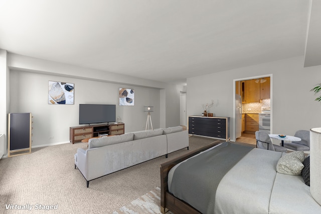 bedroom with carpet, baseboards, ensuite bathroom, and freestanding refrigerator