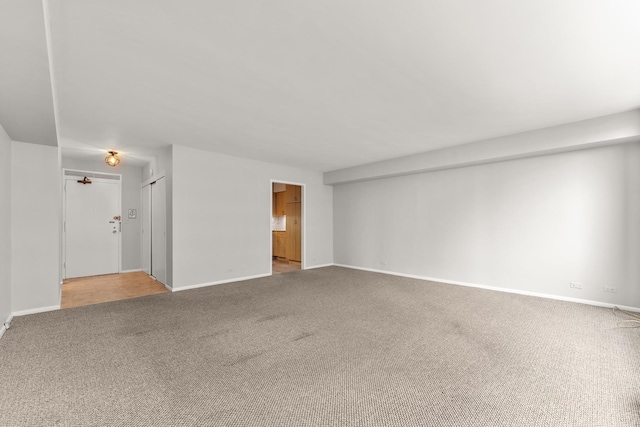 spare room featuring baseboards and carpet flooring