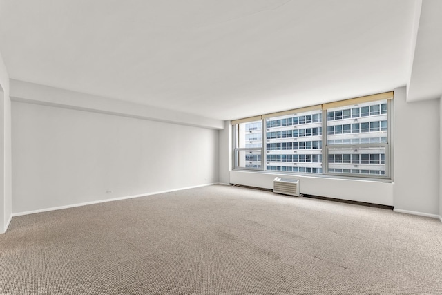 carpeted spare room featuring baseboards