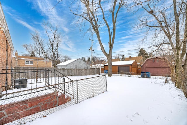 yard covered in snow with a garage and an outdoor structure