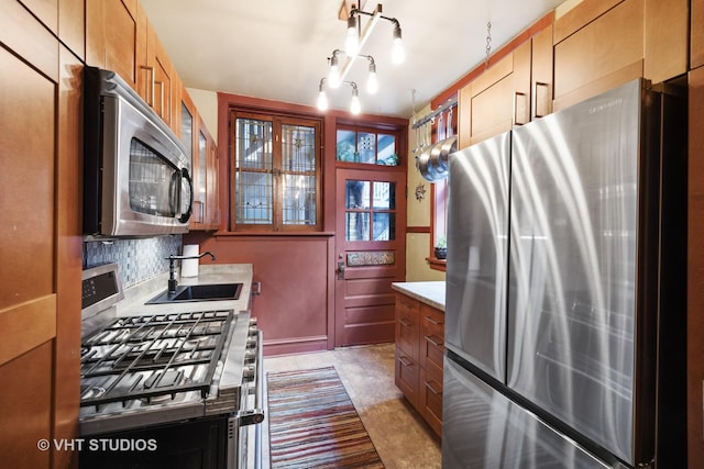 kitchen featuring glass insert cabinets, appliances with stainless steel finishes, a sink, light countertops, and backsplash