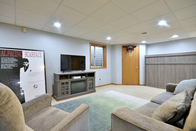 living room featuring a drop ceiling and carpet