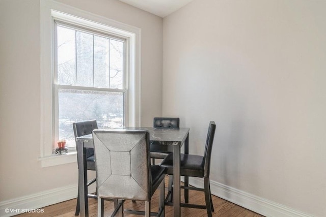 dining area featuring baseboards and wood finished floors