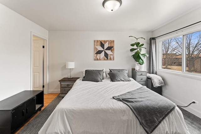 bedroom featuring baseboards and wood finished floors