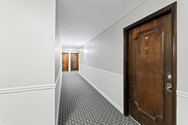hallway featuring baseboards and carpet floors