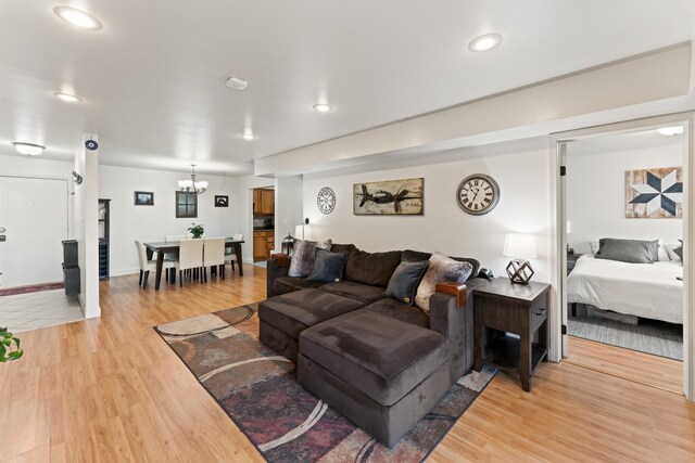 living room with light wood-style flooring, a notable chandelier, recessed lighting, and baseboards