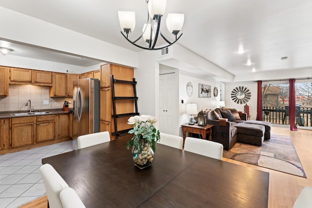 dining area with light tile patterned floors, visible vents, and an inviting chandelier