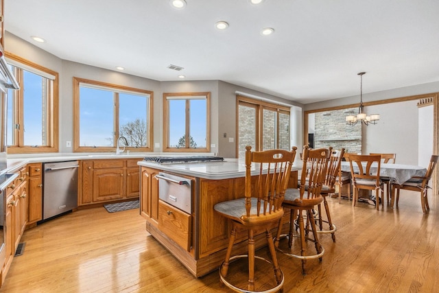 10848 Crystal Ridge Ct, Orland Park, IL 60467 - kitchen with stainless steel dishwasher, light wood-style flooring, a warming drawer, a center island, and light countertops