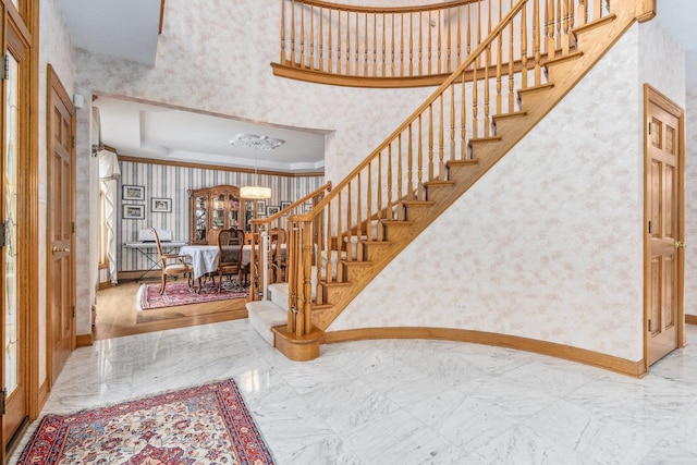 10848 Crystal Ridge Ct, Orland Park, IL 60467 - entryway with baseboards, wallpapered walls, a chandelier, crown molding, and stairs
