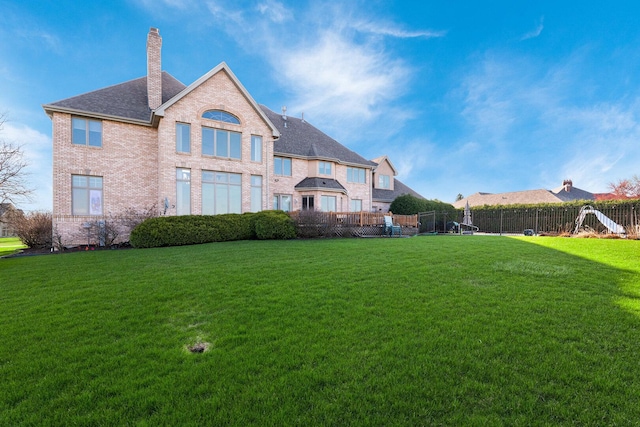 10848 Crystal Ridge Ct, Orland Park, IL 60467 - rear view of house with fence, brick siding, a chimney, and a lawn