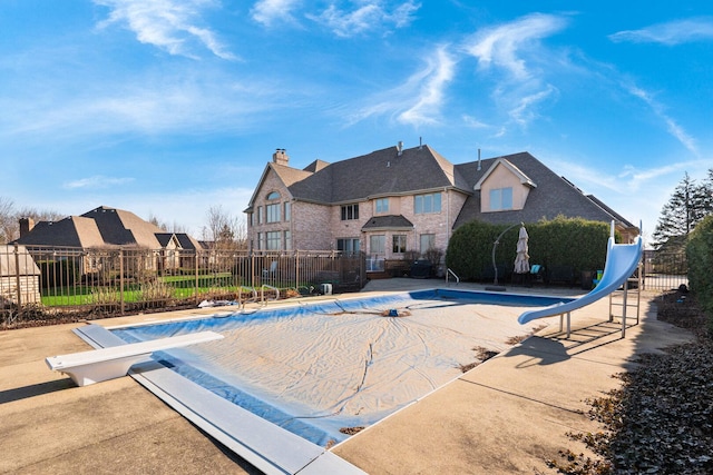 10848 Crystal Ridge Ct, Orland Park, IL 60467 - view of swimming pool featuring a fenced in pool, a diving board, a water slide, a patio area, and fence
