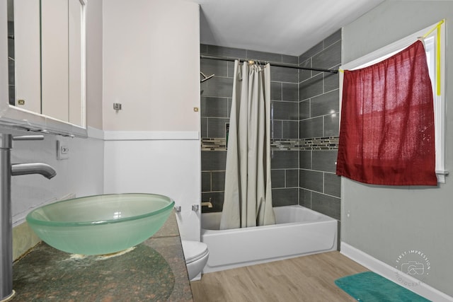 full bathroom featuring sink, toilet, shower / bath combo with shower curtain, and hardwood / wood-style floors