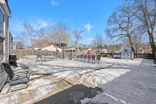 yard covered in snow featuring a storage unit