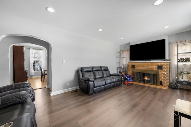 living room featuring wood-type flooring and a fireplace