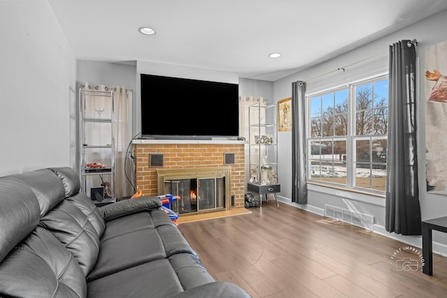 living room with hardwood / wood-style flooring and a fireplace