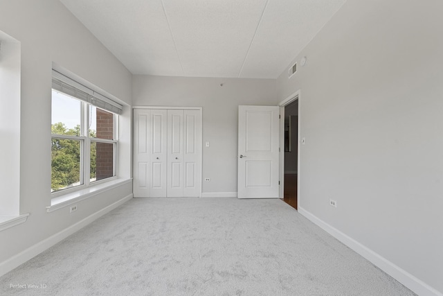 unfurnished bedroom featuring carpet and a closet