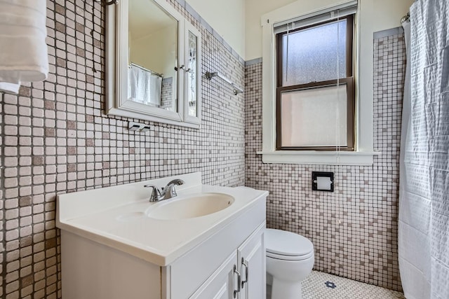 full bathroom featuring toilet, tile walls, and vanity